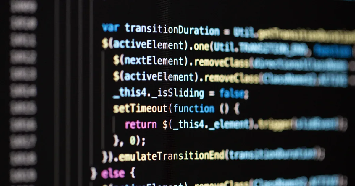 Código Python en la pantalla de un portátil junto a un cuaderno de notas