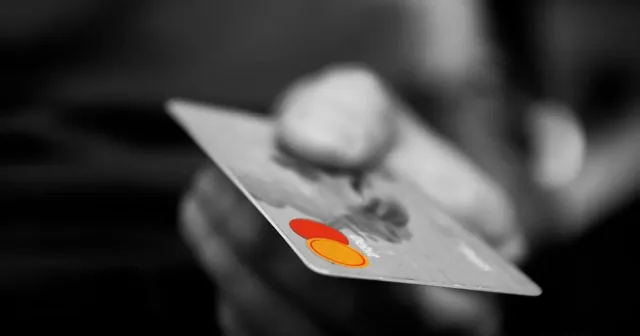 Candado y tarjeta de pago junto a un portátil que muestra una compra online segura