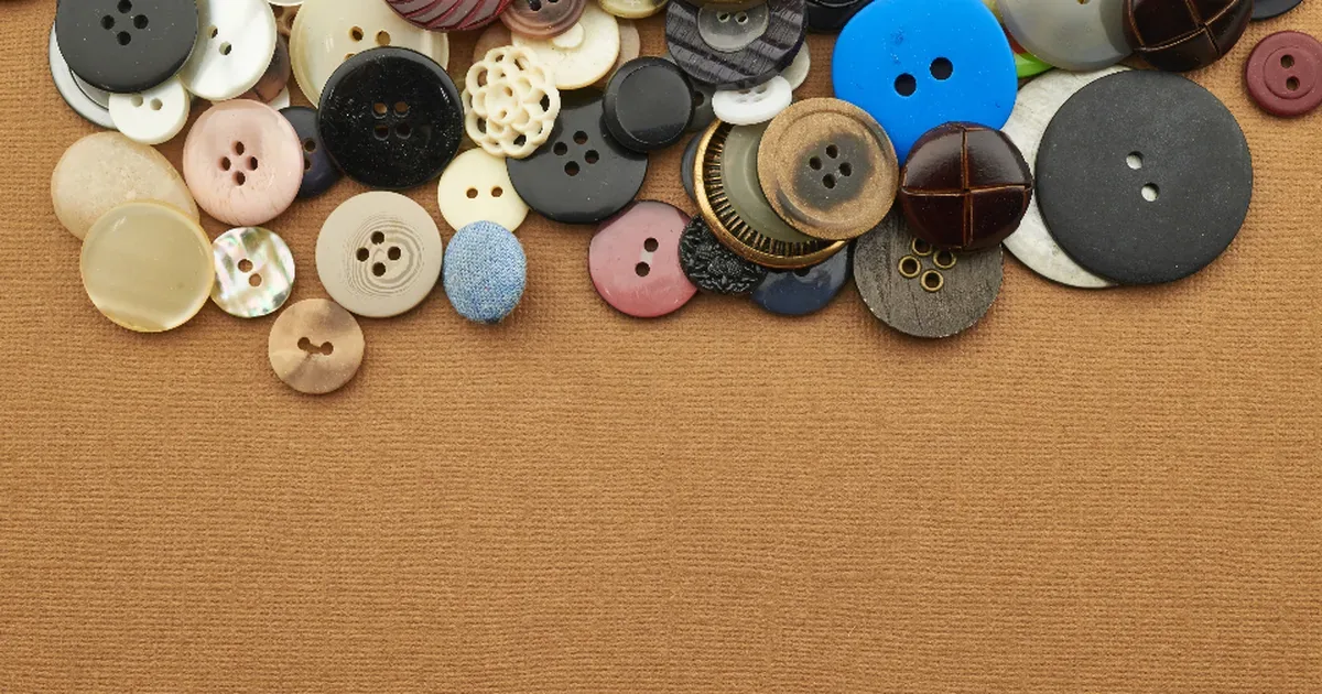 Patrones de costura y tela extendidos sobre una mesa junto a tijeras y alfileres