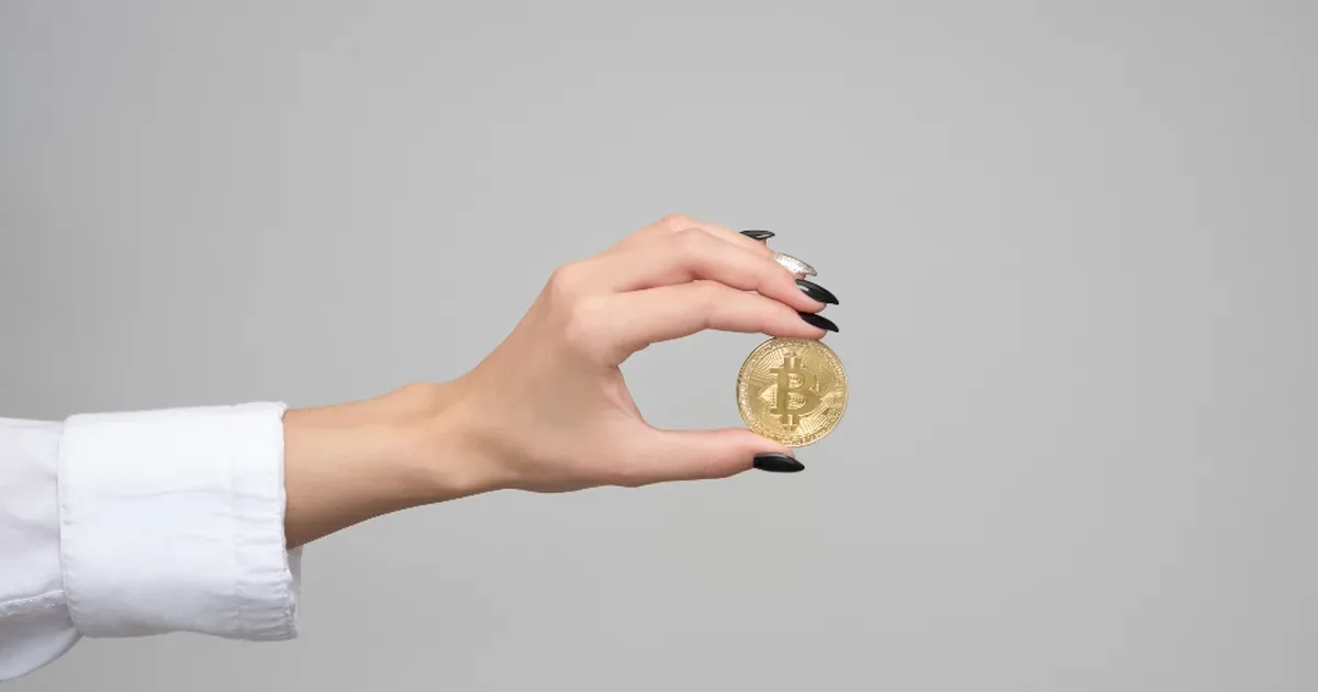 Gráfico de cotización de criptomonedas en la pantalla de un móvil junto a un portátil
