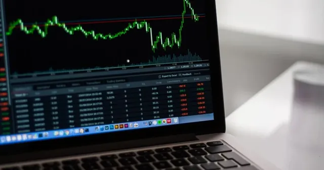 Persona revisando gráficos de la bolsa de valores en un portátil